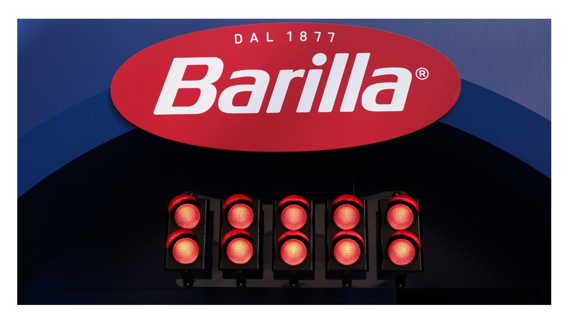 Impianto semaforico per evento con cinque semafori rossi accesi sotto il logo Barilla, ispirato alla partenza della Formula 1